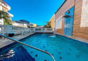a swimming pool in front of a building at Hotel Parque Atlântico in Ubatuba