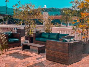un patio con sedie in vimini, divano e tavolo di Hotel Parque Atlântico a Ubatuba