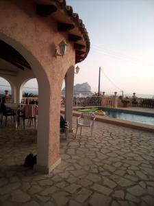 a patio with a table and chairs next to a pool at CASA CARMEN in Calpe