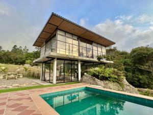 a house with a pool in front of it at Santa Helena Iscala in Chinácota