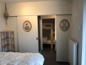 オーステンデにあるHedendaags, verzorgd appartement op unieke locatieのベッドルーム1室(ベッド1台付)が備わります。壁には猫の写真2枚が飾られています。