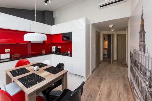 una cocina con paredes rojas y blancas y una mesa de madera. en Cozy and Large 62 m2 Apartment with Air Conditioning, Old Town, en Cracovia