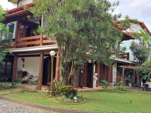 a house with a tree in front of it at Loft Verde Chic na Barra da Tijuca in Rio de Janeiro