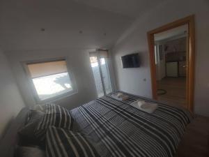 a bedroom with a bed and a window at Apartman N&A in Novi Sad