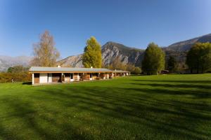 a house in a field with mountains in the background at Gite le Grand Renaud in Le Bourg-dʼOisans