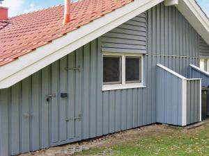 ein graues Haus mit einem Fenster und einem Dach in der Unterkunft 6 person holiday home in Otterndorf in Otterndorf