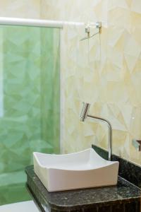 a bathroom with a sink and a shower at Flats Brasil Itacaré in Itacaré