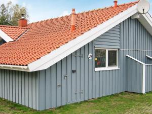 un cobertizo azul con techo naranja en 6 person holiday home in Otterndorf, en Otterndorf