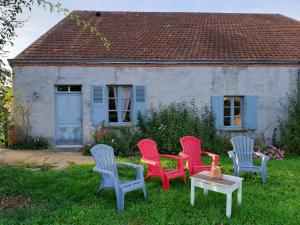 four chairs and a table in front of a house at Notre village Papillon bed&breakfast in Néret