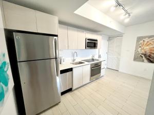a large kitchen with a stainless steel refrigerator at 1 BD 1 BA @Beachwalk Resort in Hallandale Beach