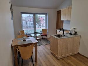a kitchen with a sink and a table with chairs at Neris apartments in Šiauliai