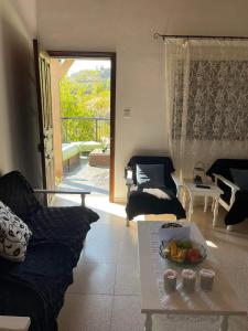 uma sala de estar com um sofá e uma mesa em Veranda em Agros