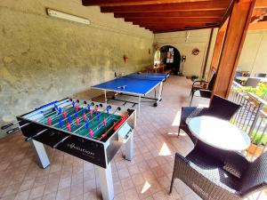due tavoli da ping pong in una stanza con sedie di Residence Casa Silvana a Tignale