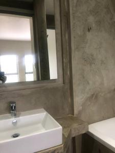 a bathroom with a white sink and a mirror at 1 The Eighteenth, Prince’s Grant Golf Estate in Blythedale