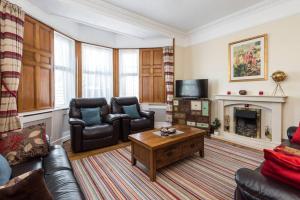 een woonkamer met een bank en een tafel bij Abercorn Lodge Semi-Detached House in Edinburgh