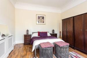 een slaapkamer met een groot bed met 2 krukken bij Abercorn Lodge Semi-Detached House in Edinburgh
