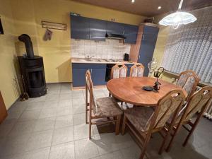 eine Küche mit einem Holztisch, Stühlen und einem Herd in der Unterkunft Ferienhaus Sofia in Urschmitt