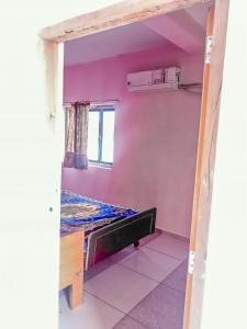 a small room with a bed and a window at Krishna Homestay in Garudeshwar