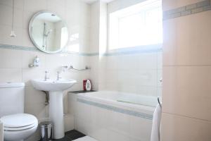 e bagno con lavandino, servizi igienici e vasca. di Twelve Thirty Serviced Apartments - Balham a Londra