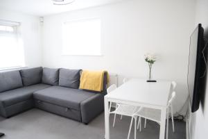 uma sala de estar com um sofá e uma mesa em Twelve Thirty Serviced Apartments - Balham em Londres