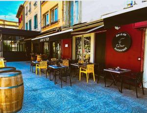 une terrasse d'un restaurant avec des tables et des chaises dans l'établissement Les Appartements du Cep’t, à Mazamet