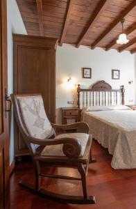 a bedroom with a bed and a rocking chair at Apartamentos Porcia in Tapia de Casariego