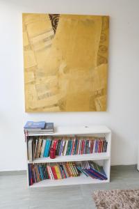 Alma Casa Boutique في أريكيبا: لوحة معلقة فوق رف الكتاب الأبيض مع الكتب