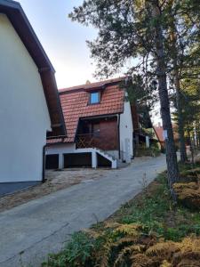 ein Haus mit rotem Dach und Auffahrt in der Unterkunft Šumor šume - Tara in Kaludjerske Bare