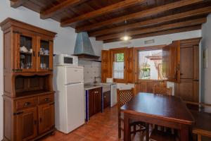 a kitchen with a table and a white refrigerator at Apartamentos Porcia in Tapia de Casariego