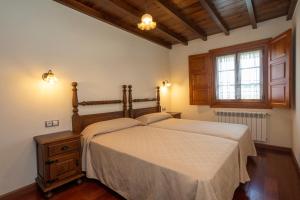 una camera con un grande letto e una finestra di Apartamentos Porcia a Tapia de Casariego
