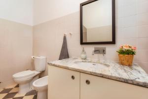 a bathroom with a sink and a toilet and a mirror at Female Hostel in Faro