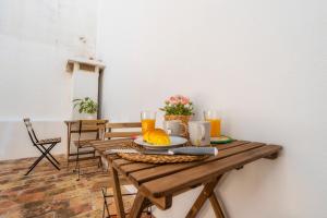 Female Hostel في فارو: طاولة خشبية مع صحن من الطعام وعصير برتقال
