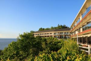 a building on a hill next to the ocean at Auberge de la Pointe in Rivière-du-Loup