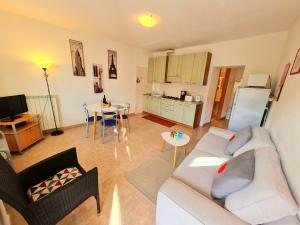 a living room with a white couch and a kitchen at Residence Casa Silvana in Tignale