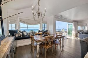 a dining room with a table and chairs and a couch at Luxury Ocean Views & Steps To The Sand - Tower 36 Upper Condo Unit in Carlsbad