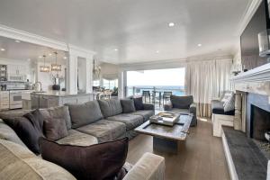 a living room with a couch and a table at Luxury Ocean Views & Steps To The Sand - Tower 36 Upper Condo Unit in Carlsbad