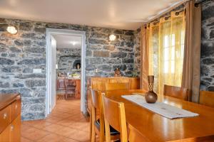 a kitchen and dining room with a stone wall at Casa do Pombal, a Home in Madeira in Arco da Calheta