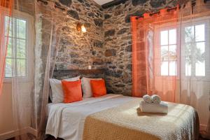 a bedroom with a bed and two windows at Casa do Pombal, a Home in Madeira in Arco da Calheta