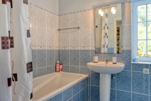 a bathroom with a tub and a sink and a bath tubermottermott at Casa do Pombal, a Home in Madeira in Arco da Calheta +35 photos