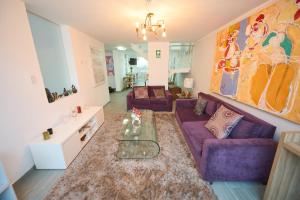 una sala de estar con sofás morados y una alfombra. en Alma Casa Boutique, en Arequipa