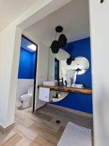 La salle de bains est pourvue d'un mur bleu et d'un miroir. dans l'établissement CASA NDOMI TEPOZ, à Tepoztlán