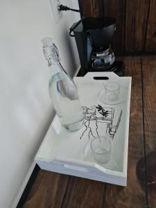 Una botella y dos vasos en una caja blanca. en CASA NDOMI TEPOZ en Tepoztlán