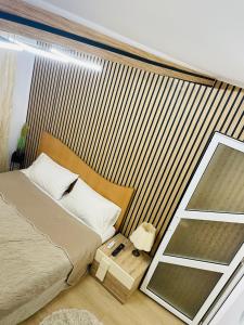 1 dormitorio con 1 cama grande y espejo en Imperium DK Apartament, en Giurgiu