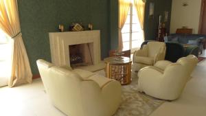 a living room with white chairs and a fireplace at Casa Deco Hotel Boutique in Cochabamba