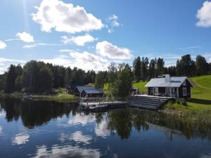 Hugsnäset Semesterstugor och Fiske في Gällö: منزل على بحيرة مع رصيف
