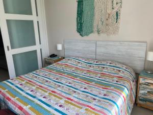 Un dormitorio con una cama con una colcha colorida. en Green Park - Studio, en Punta del Este