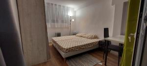ein kleines Schlafzimmer mit einem Bett und einem Schreibtisch in der Unterkunft Vie Agréable JARDIN GRANDE CUISINE SALON 2 CHAMBRES in Soisy-sous-Montmorency