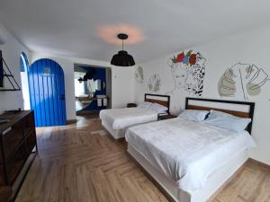 - une chambre avec 2 lits et une porte bleue dans l'établissement CASA NDOMI TEPOZ, à Tepoztlán