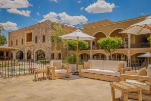 a patio with furniture and umbrellas in front of a building at HC HACIENDA CATRINA HOTEL BOUTIQUE in Silao