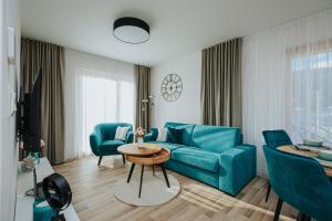 uma sala de estar com um sofá azul e uma mesa em Apartmán Hillside X34, Kubínska Hoľa em Dolný Kubín